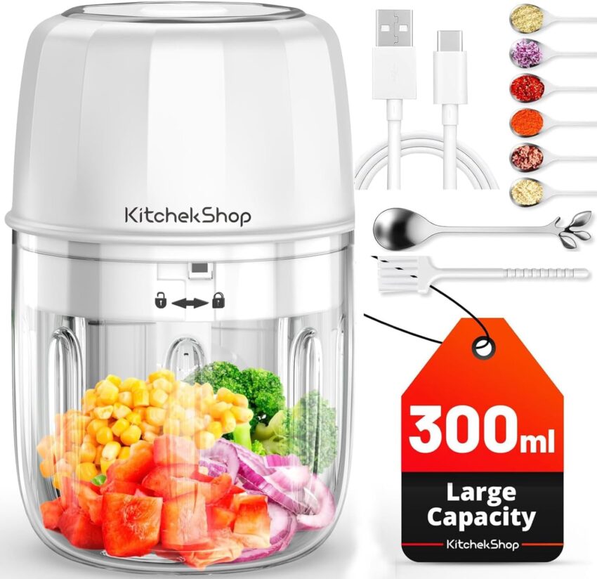 Compact white and clear mini food chopper filled with vibrant chopped vegetables, surrounded by kitchen accessories.
