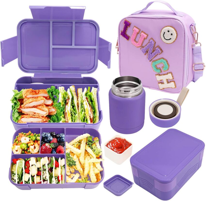 Open purple bento box with colorful kid-friendly food, surrounded by matching lunch bag, thermos, and snack containers.